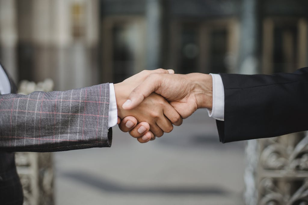 A close-up of two businesspeople shaking hands, symbolizing cooperation and partnership.